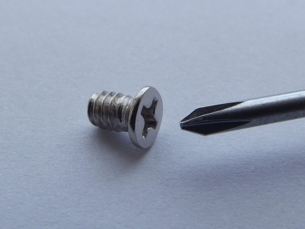 Screwdriver placed beside the screw