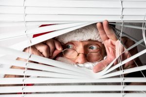 Santa Clause peeks through a window blind